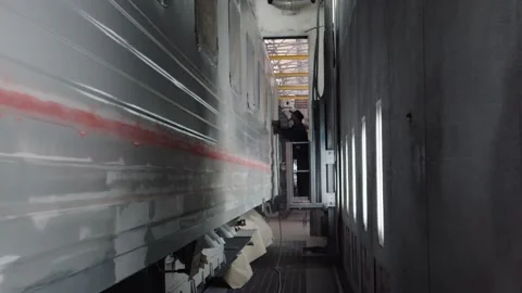 The paint shop of the wagon plant. A worker in overalls and a respirator is Stock Footage 196357182