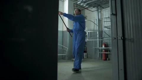 Paint shop worker in a protective uniform moves products Stock Footage 179706987