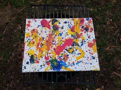 Paint splatter mess or drips on white canvas on metal rack Stock Photos
