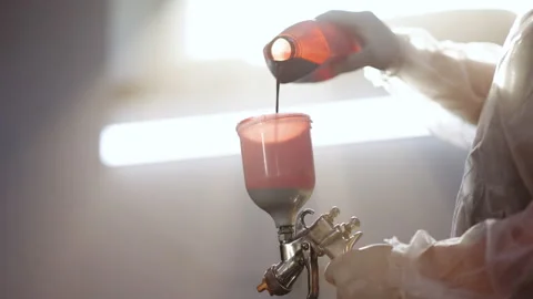 Paint-spraying gun is getting used by the worker to colour the car. Car painting Stock Footage 194559936