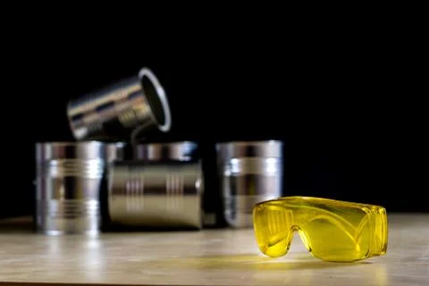 Paint tins set on a workshop table. Table with light wood, Stock Photos
