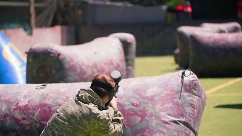 Paintball player aiming shooting HD game slow-motion video. Man with gun war Stock Footage 79237277
