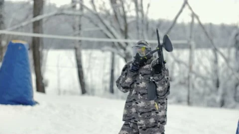 Paintball players in winter walking through snow in nature with paintball guns Stock Footage 231807475