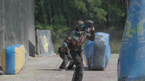 Paintballplayer on the Field while a Battle is going on in Slow Motion Stock Footage 66442232