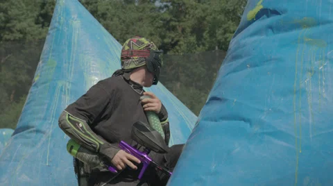 Paintballplayer on the Field while a Battle is going on Stock Footage 66443115