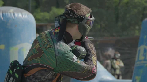 Paintballplayer on the Field while a Battle is going on in Slow Motion Stock Footage 66443523