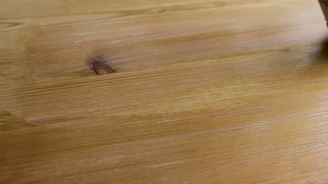 Paintbrush applying clear varnish or protective coating to a wooden board Stock Footage 338232629
