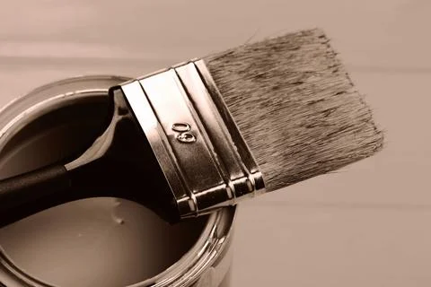 Paintbrush balanced on a can, showcasing the warm tone of paint Stock Photos
