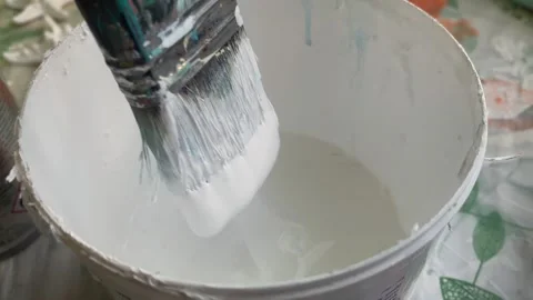 Paintbrush dipping bucket pristine white paint preparing for home improvement. Stock Footage 340322042