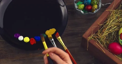 Paintbrushes on palette. Top view close up video of female hand with brushes and Video stock 150956696