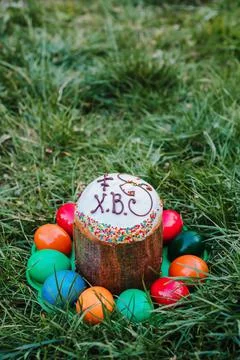 Painted and decorative Easter cake and eggs in the grass. Top view, copy spac Stock Photos