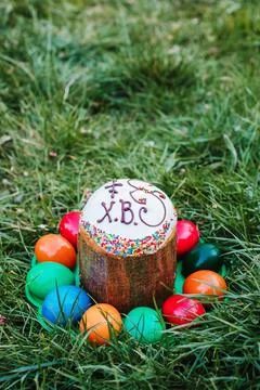 Painted and decorative Easter cake and eggs in the grass. Top view, copy space Stock Photos