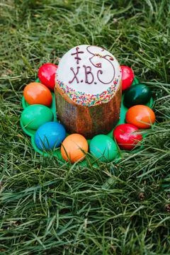 Painted and decorative Easter cake and eggs in the grass. Top view, copy space Stock Photos