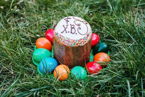 Painted and decorative Easter cake and eggs in the grass. Top view, copy space Stock Photos