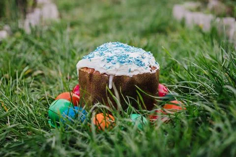 Painted and decorative Easter cake and eggs in the grass. Top view, copy space Stock Photos