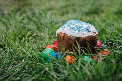 Painted and decorative Easter cake and eggs in the grass. Top view, copy space Stock Photos