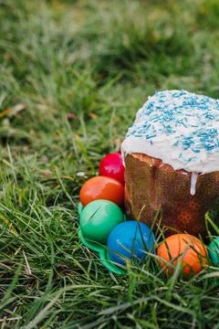 Painted and decorative Easter cake and eggs in the grass. Top view, copy space Stock Photos