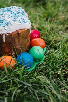 Painted and decorative Easter cake and eggs in the grass. Top view, copy space Stock Photos