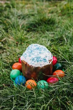 Painted and decorative Easter cake and eggs in the grass. Top view, copy space Stock Photos