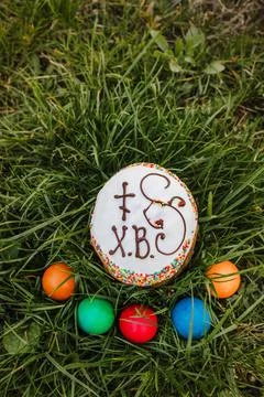 Painted and decorative Easter cake and eggs in the grass. Top view, copy space Stock Photos