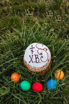 Painted and decorative Easter cake and eggs in the grass. Top view, copy space Stock Photos