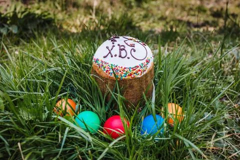 Painted and decorative Easter cake and eggs in the grass. Top view, copy space Stock Photos