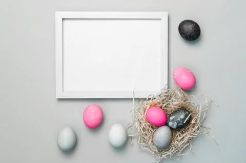 Painted colorful Easter eggs on gray background and frame for text Stock Photos