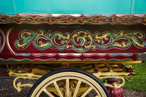 The painted decorated side panel of a bow top gypsy caravan and large wooden Stock Photos