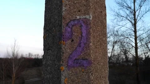 Painted digit 2. The number two is written in purple paint on a pillar. Serial Stock Footage 311481640
