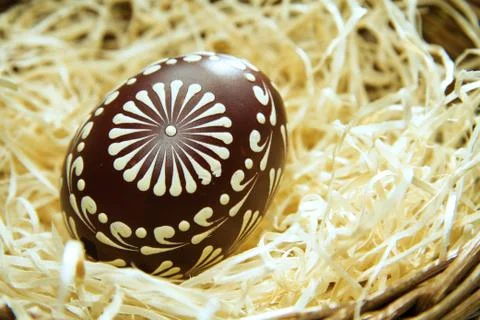 Painted easter egg in a basket with straw, easter background Stock Photos