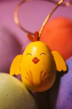 Painted Easter egg in a form of a cute funny yellow toy chicken. Colorful eggs Stock Photos