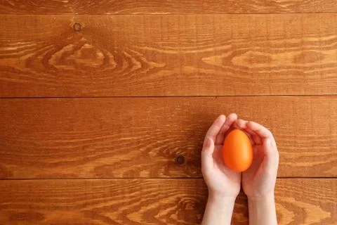 Painted Easter Egg In Hands Wooden Background Stock Photos