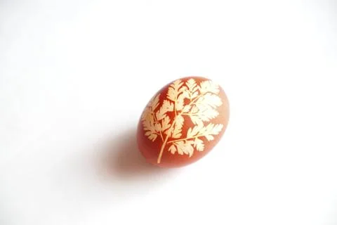 Painted Easter egg on a white background. Floral pattern on a red eggshell. Stock Photos