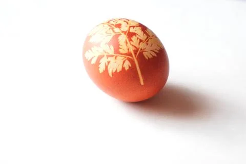 Painted Easter egg on a white background. Floral pattern on a red eggshell. 스톡 사진
