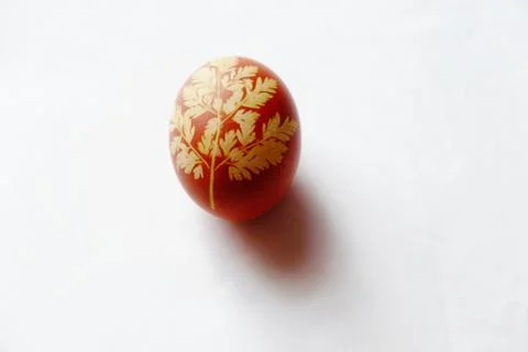 Painted Easter egg on a white background. Floral pattern on a red eggshell. 스톡 사진