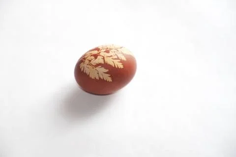 Painted Easter egg on a white background. Floral pattern on a red eggshell. Stock Photos