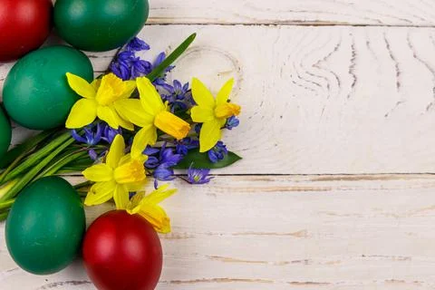 Painted Easter eggs and bouquet of yellow daffodils and blue scilla flowers Stock Photos