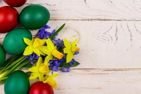 Painted Easter eggs and bouquet of yellow daffodils and blue scilla flowers Foto stock