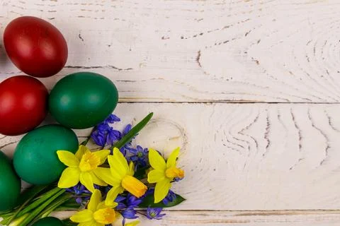Painted Easter eggs and bouquet of yellow daffodils and blue scilla flowers Foto stock
