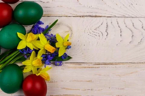 Painted Easter eggs and bouquet of yellow daffodils and blue scilla flowers Foto stock