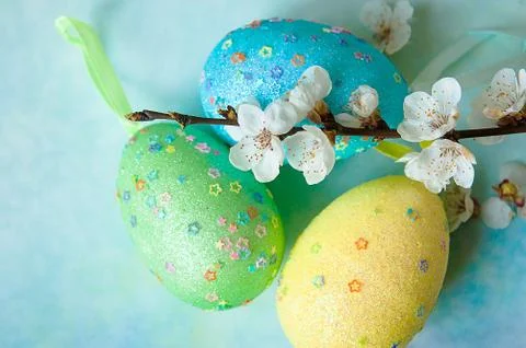 Painted easter eggs and branches of spring sakura closeup on a light blue Stock Photos