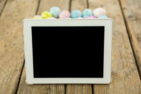 Painted Easter eggs and digital tablet on wooden surface Stock-Fotos