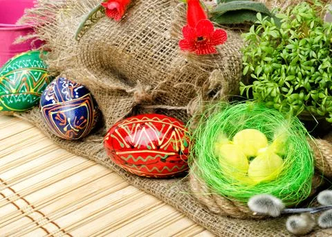 Painted Easter eggs and willow branches on a background of burlap. Stock Photos