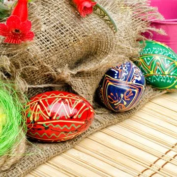 Painted Easter eggs and willow branches on a background of burlap. Stock Photos