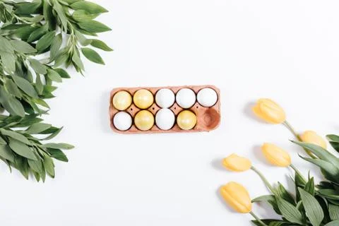 Painted Easter eggs and yellow tulips on white background Stock Photos