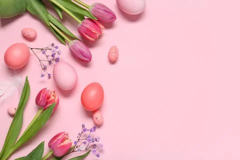 Painted Easter eggs with beautiful flowers and feather on pink background Stock Photos