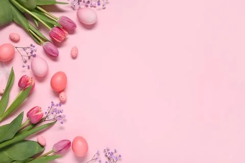 Painted Easter eggs with beautiful flowers and feather on pink background Stock Photos
