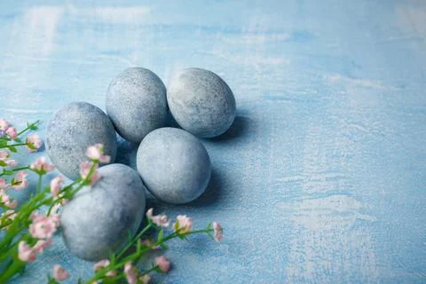 Painted Easter eggs on blue background with pink flowers. Spring holiday Stock Photos