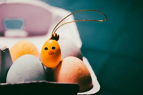 Painted Easter eggs on blue background. Bright yellow funny cute cool toy Foto stock