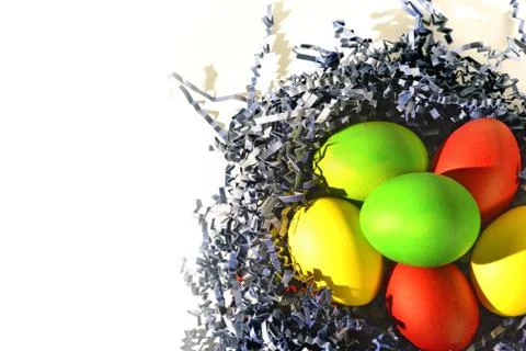 Painted Easter eggs in blue paper bird nest on white Foto stock